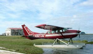 Cessna-206 on floats - lodge in background